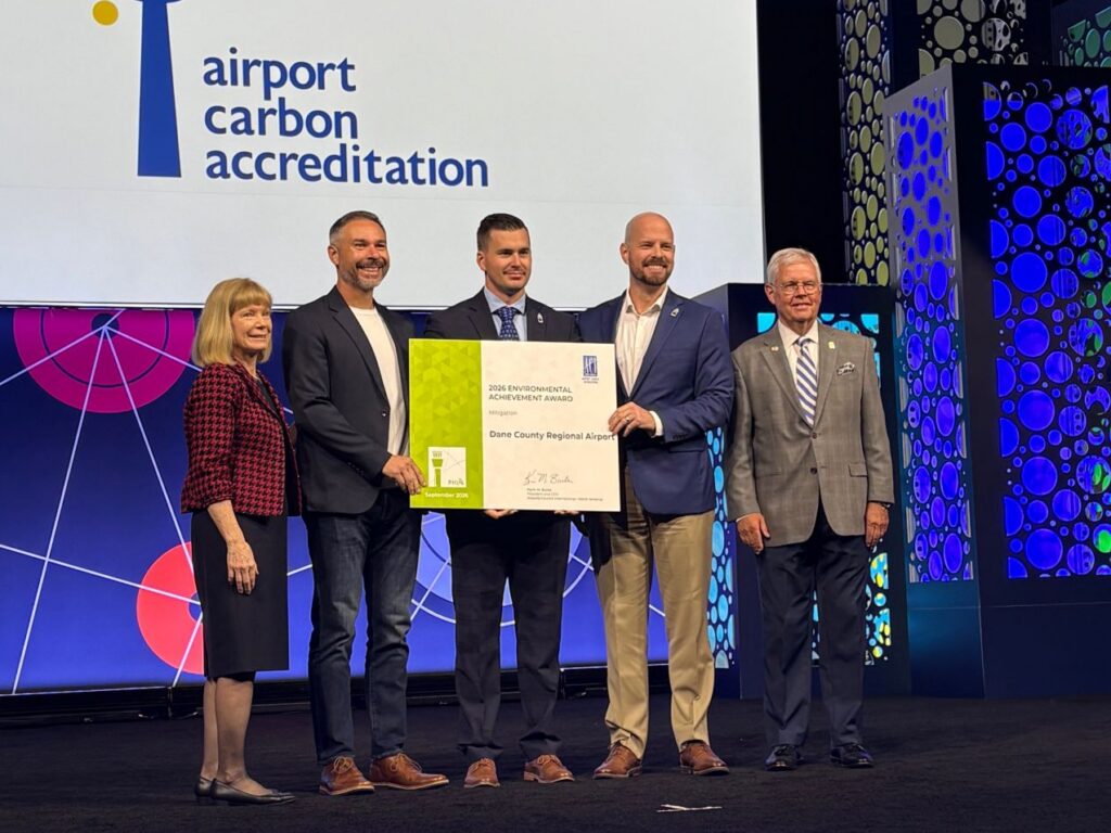 Dane County Regional Airport representatives accept the 2026 Environmental Achievement Award (Mitigation category) on stage at the ACI-NA Annual Conference, Philadelphia, September 16, 2026.